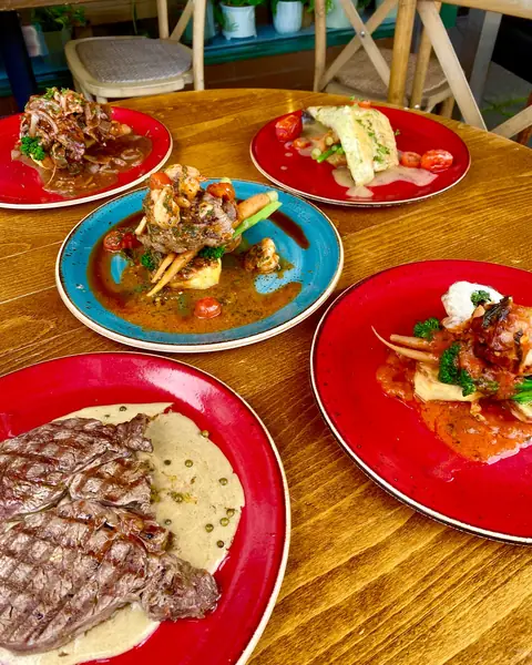 Steak and starters on red glazed plates