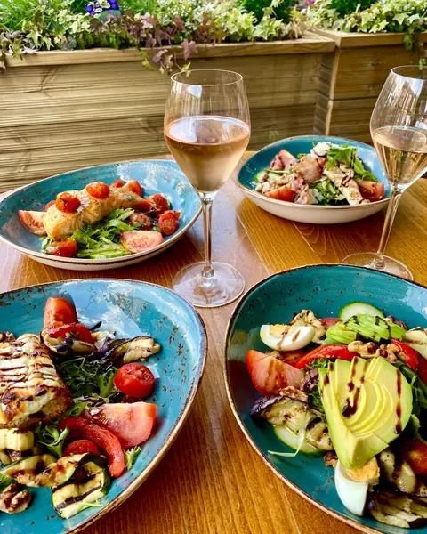 Salads and glasses of rosé on a garden table
