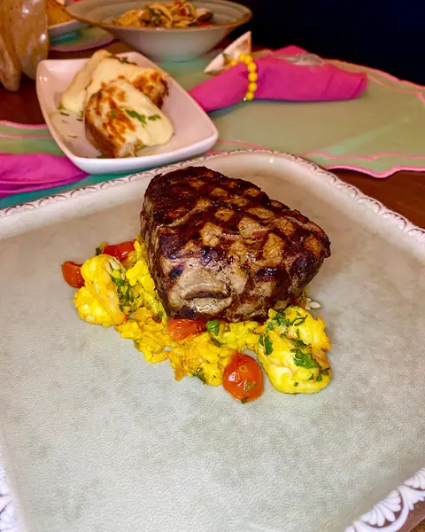 Grilled steak with scrambled eggs and tomatoes