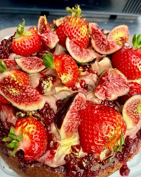 A cake crowned with figs and strawberries